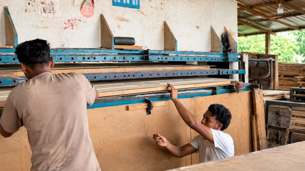 Craftsman Nepal team pressing molded door panels in Kawasoti